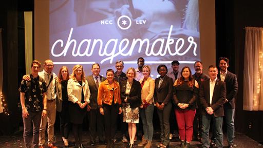 Students and faculty posing on stage at the Changemaker Challenge.