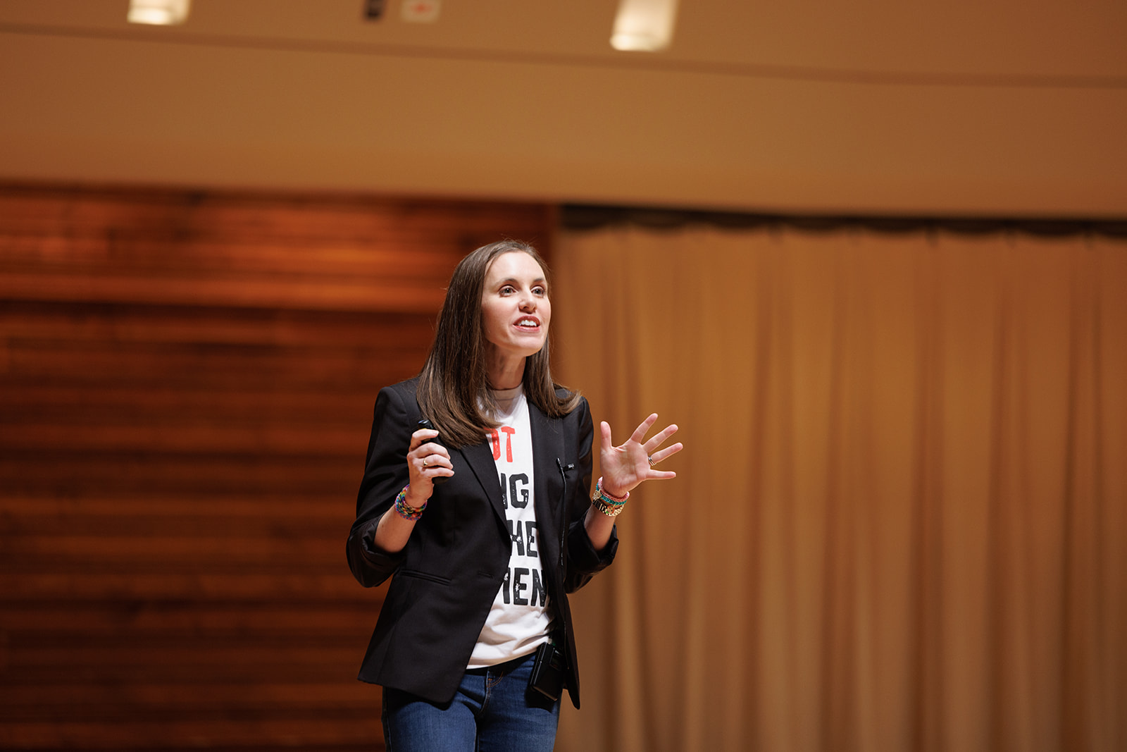 A woman talking on the stage of the Wentz Concert Hall.