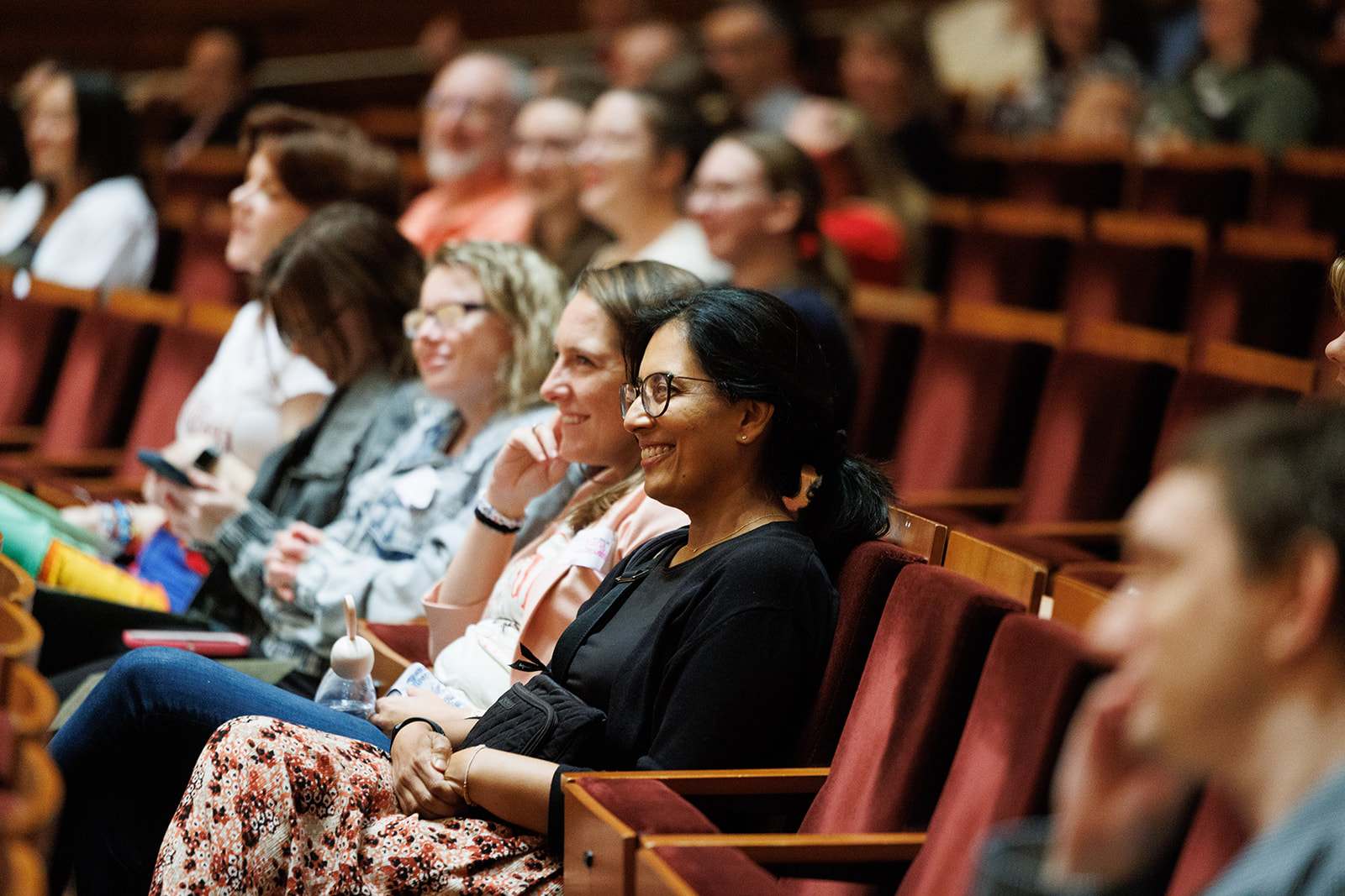 Women sitting and smiling in the Wentz Concert Hall.