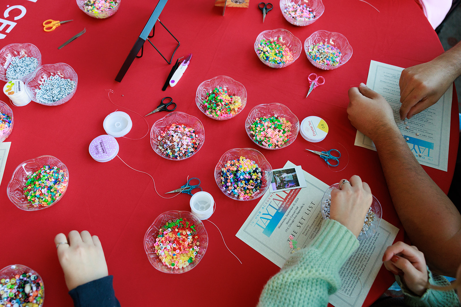 A table covered in supplies for making friendship bracelets.