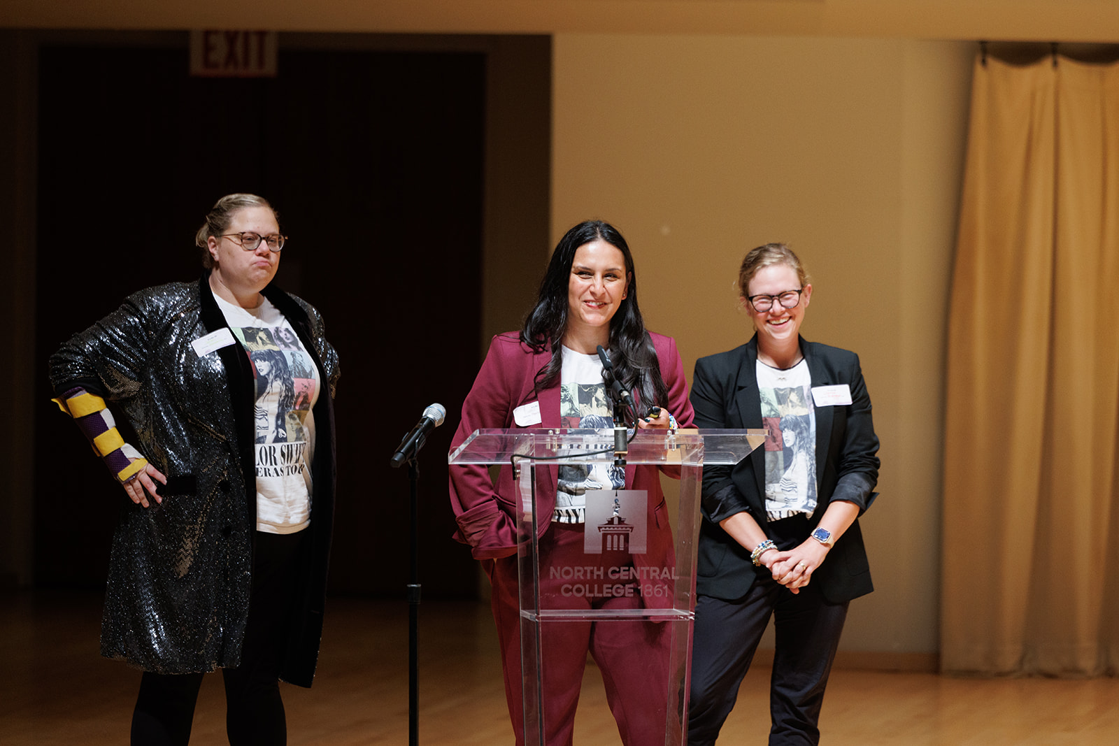 Three women talking and posing on the stage of the Wentz Concert Hall.