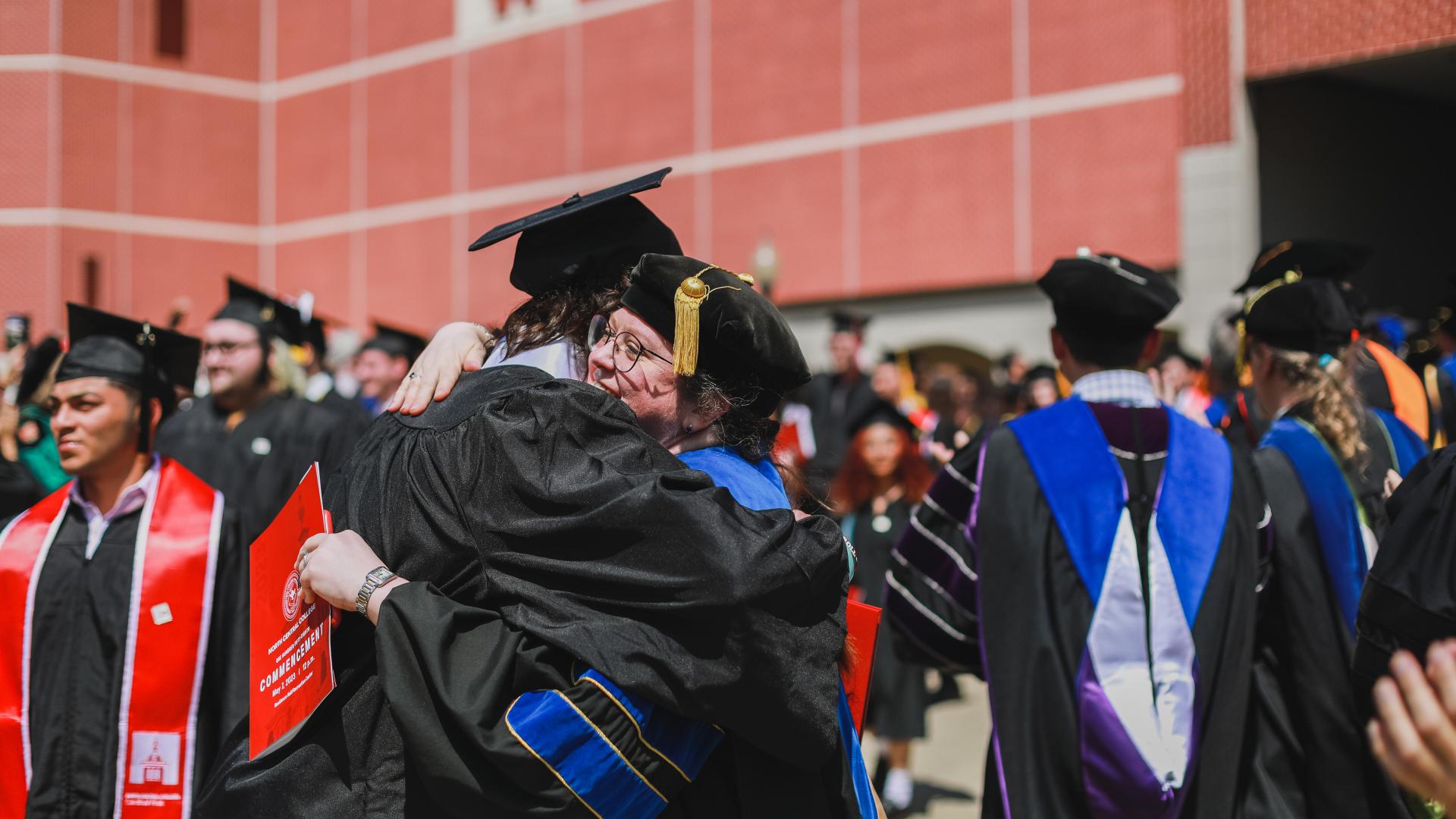 Student hugging professor at graduation