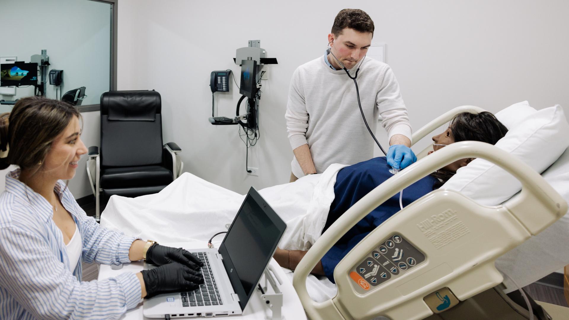 Two nursing students working with patient mannequin