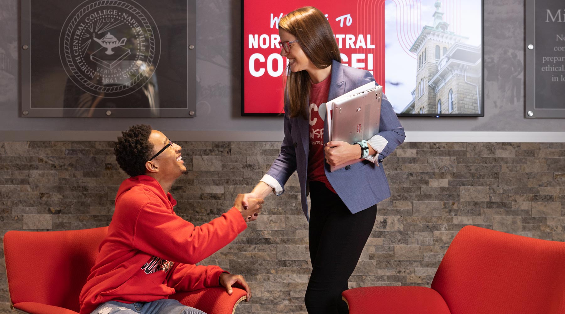 student shaking hands with admissions counselor