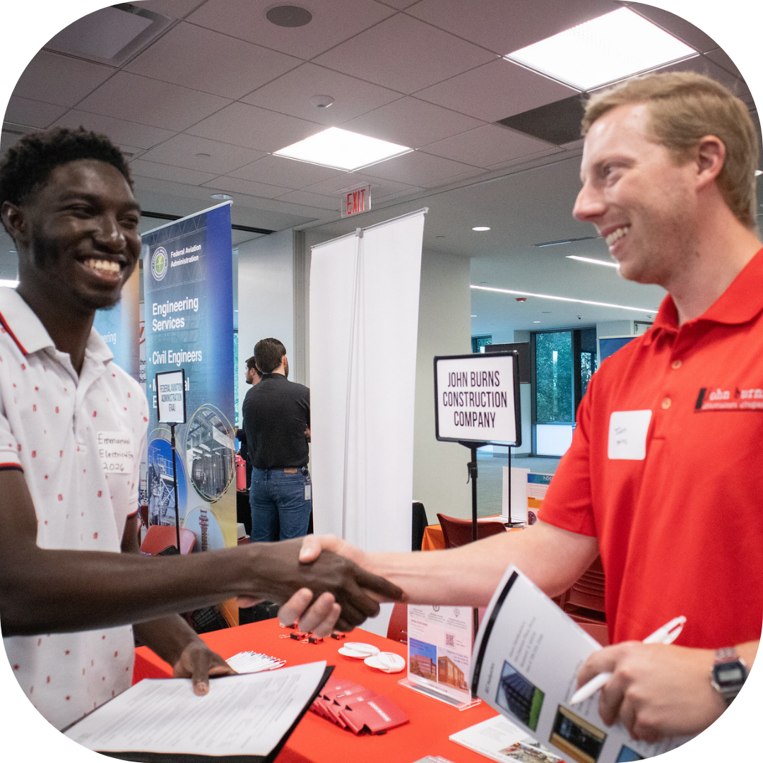 student shaking hands with recruiter at career fair