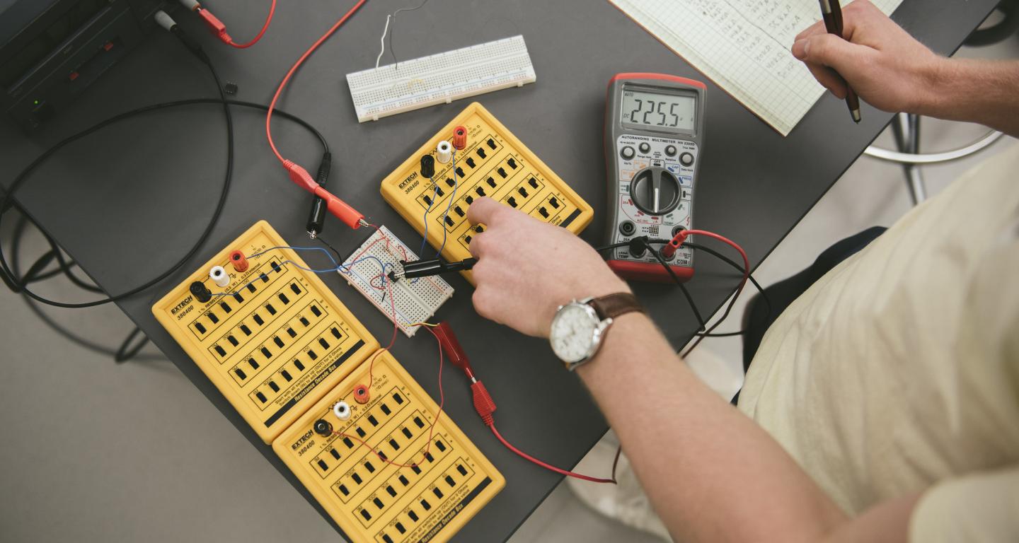 A North Central College electrical engineering student works with some devices.