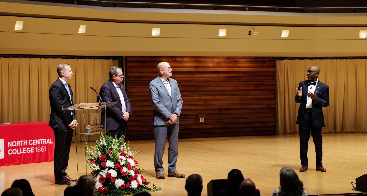 Dean David Green on stage with Thomas J. Paleka ’83, David E. Thomson, and President G-P.