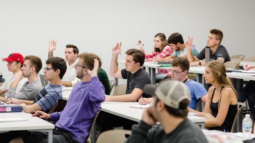 North Central College students raising their hands during a class.