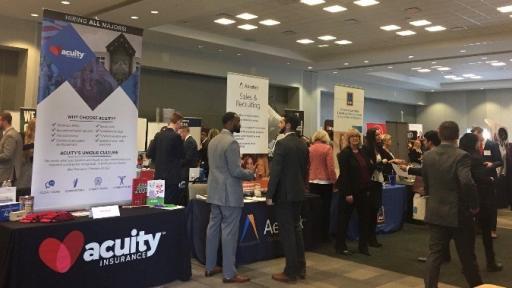 North Central College students touring a job fair with booths from local companies.